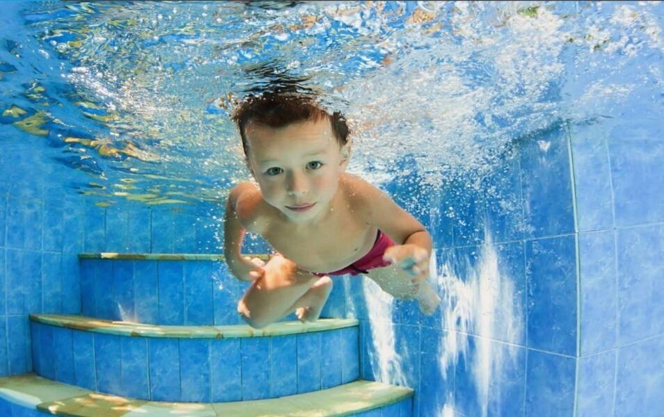 Ein Junge schwimmt in einem Swimming Pool